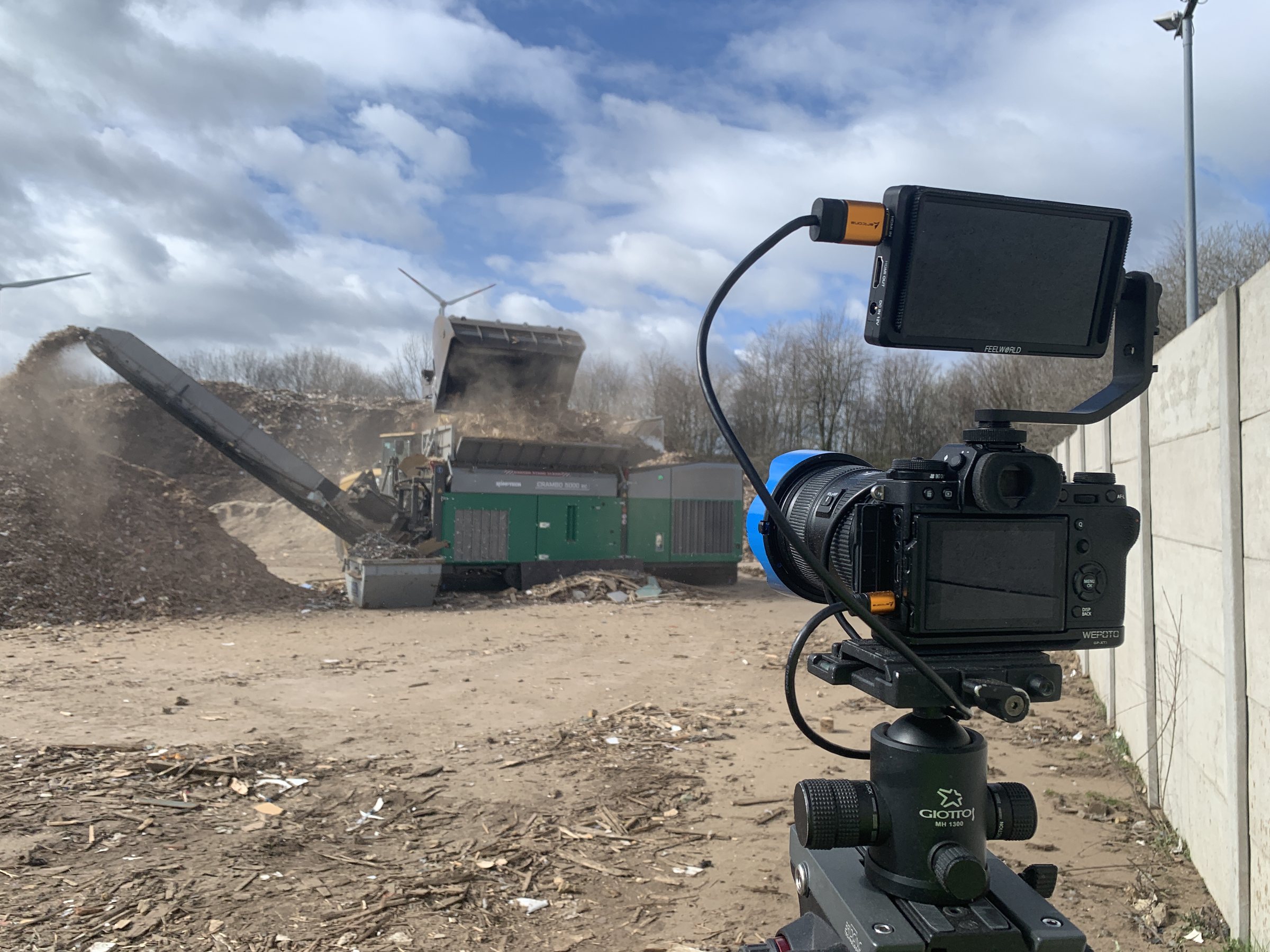 Kamera auf Stativ mit externem Monitor bei Dreharbeiten auf einem Recyclinghof