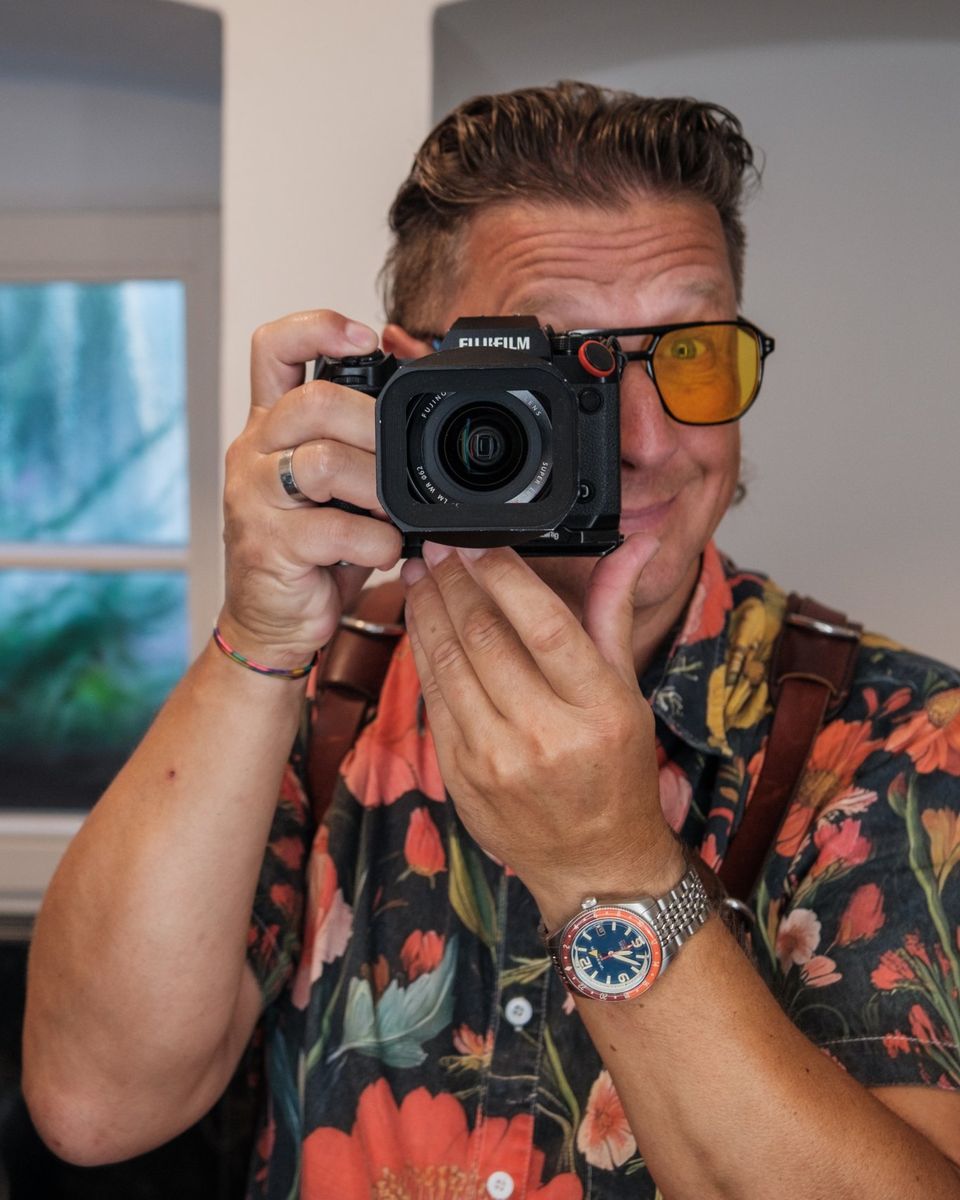 Torsten Kellermann mit Fujifilm-Kamera vor dem Gesicht, Spiegel-Selbstportrait